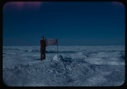Image of Peter Rand standing with flag at farthest north