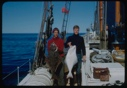 Image of Two crewmen holding halibut