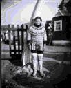 Image of Eskimo [Inuk] woman in dress-costume by church