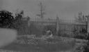Image of Child in garden; picket fence